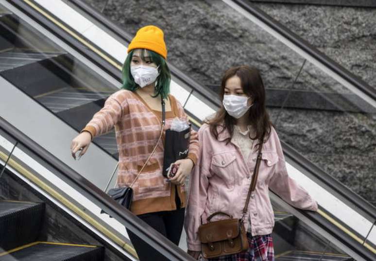 Mulheres vestem máscaras de proteção em Guangzhou, na China