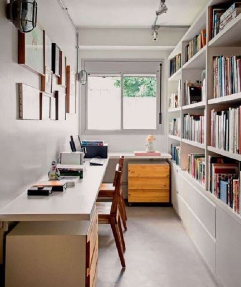 26. A estante embutida com diversas prateleiras auxilia na organiza&ccedil;&atilde;o do escrit&oacute;rio planejado. Fonte: Decora&ccedil;&atilde;o e Projetos