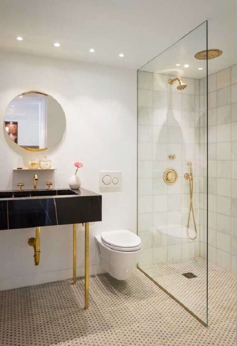 21. Bancada de m&aacute;rmore para banheiro com detalhes em dourado e espelho redondo &ndash; Foto: Ideias Decor