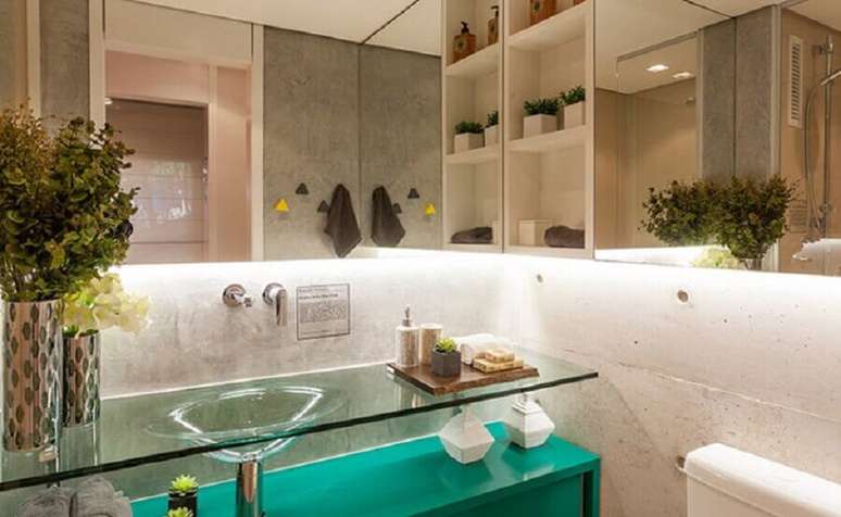 6. Decora&ccedil;&atilde;o moderna com bancada de vidro para banheiro com m&oacute;vel azul na parte debaixo &ndash; Foto: Fernanda Marques