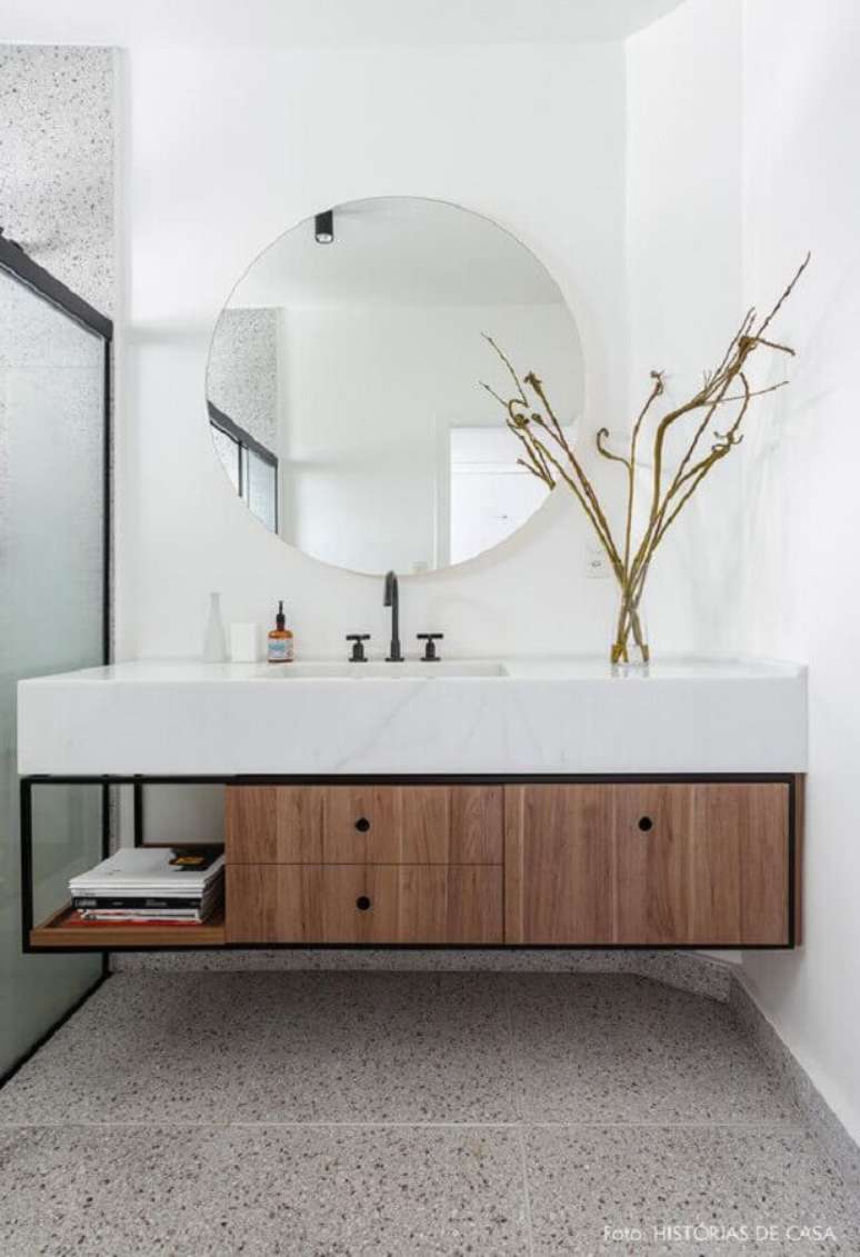 55. Decoração com bancada de mármore para banheiro moderno com espelho redondo – Foto: Histórias de Casa