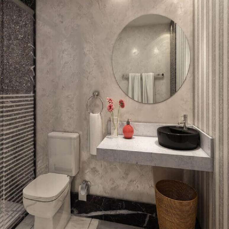 57. Modelo de bancada de granito para banheiro pequeno com parede de cimento queimado e espelho redondo – Foto: Assetproject