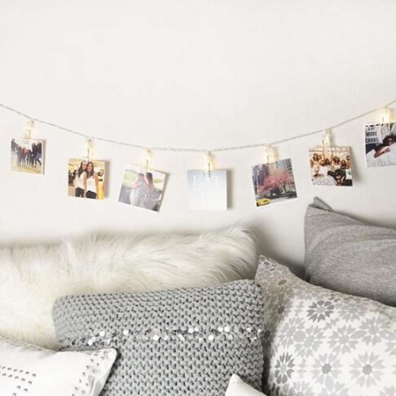 34. Em um quarto monocrom&aacute;tico, o varal de fotos colore o ambiente