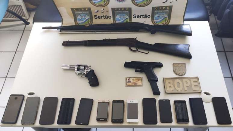 Polícia baiana exibe armas e celulares que diz ter encontrado onde Adriano Nóbrega estava escondido