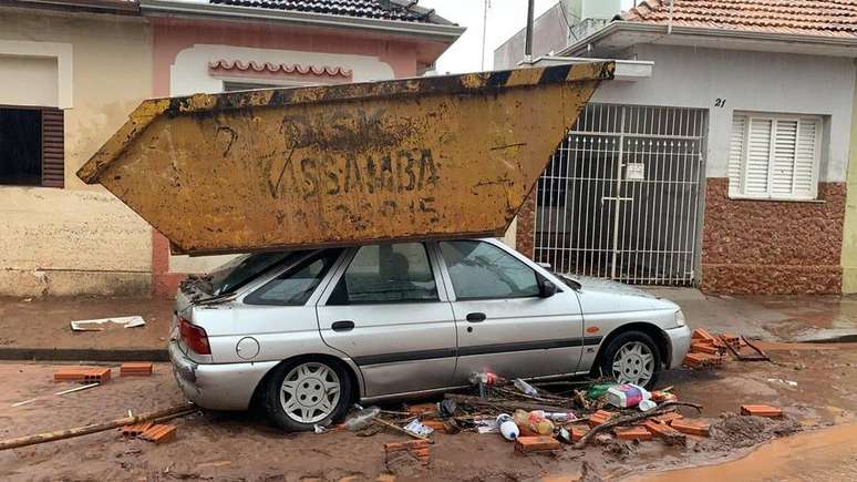 Com a força da correnteza, uma caçamba de aço foi parar sobre o capô de um carro, em Botucatu, interior de São Paulo.