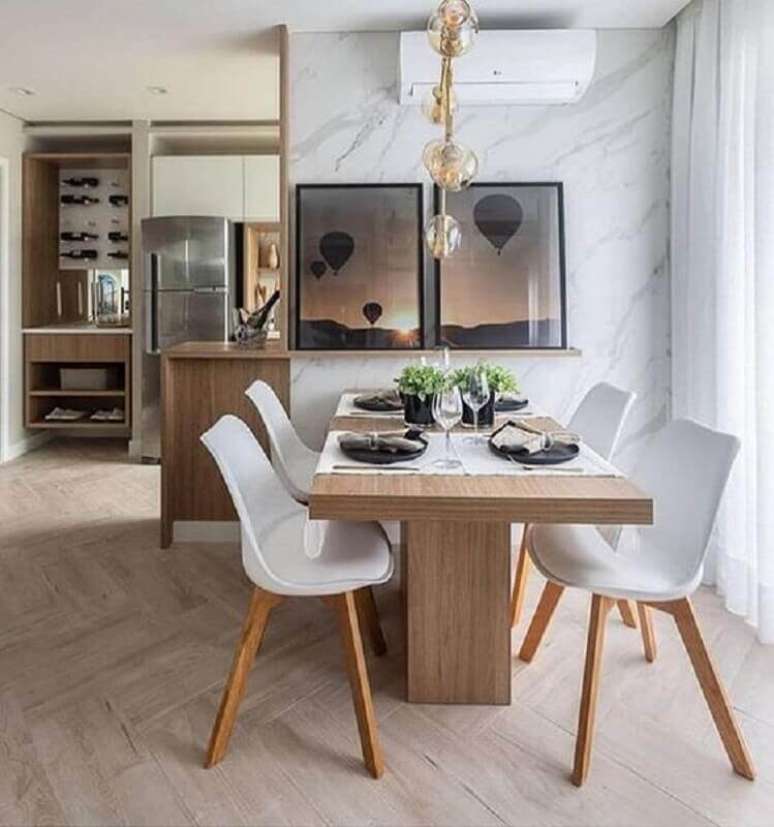 10. Sala de jantar moderna decorada com mármore para revestimento de parede e mesa com cadeira branca – Foto: Homedit