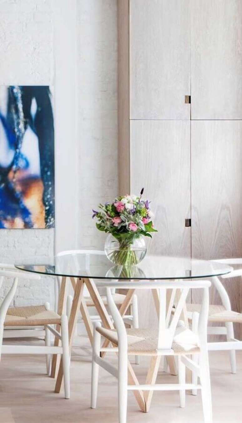 7. Decoração clean com mesa de vidro redonda e cadeira branca para sala de jantar – Foto: Pinterest