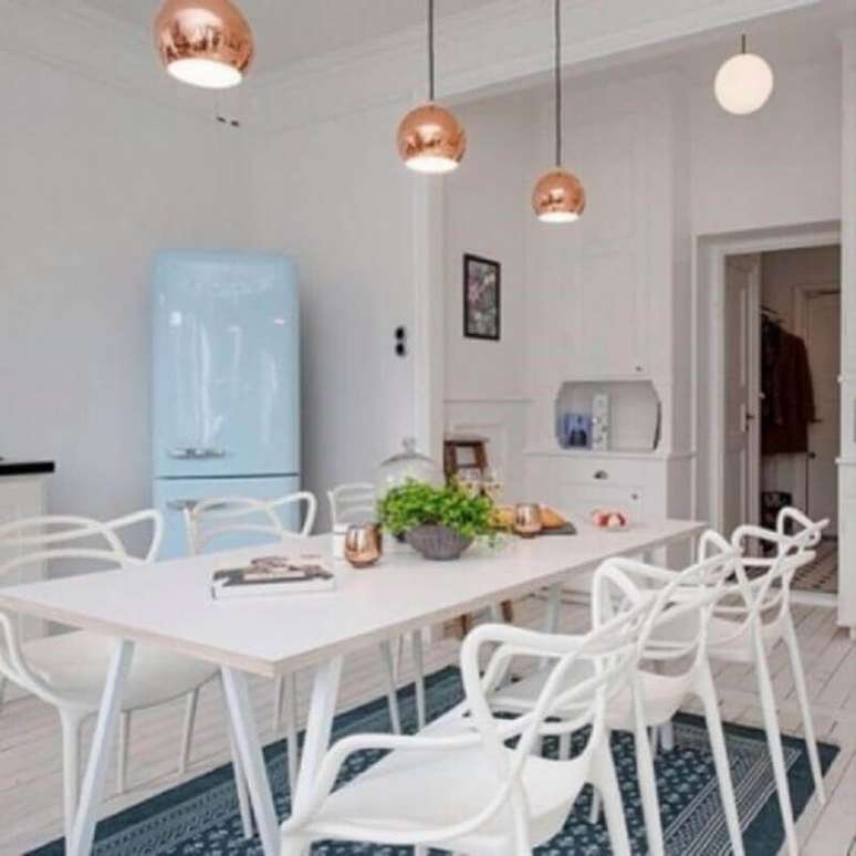 53. Mesa com cadeira branca para cozinha com pendentes rose gold e geladeira azul &ndash; Foto: Eduardo Cavalcanti Castro