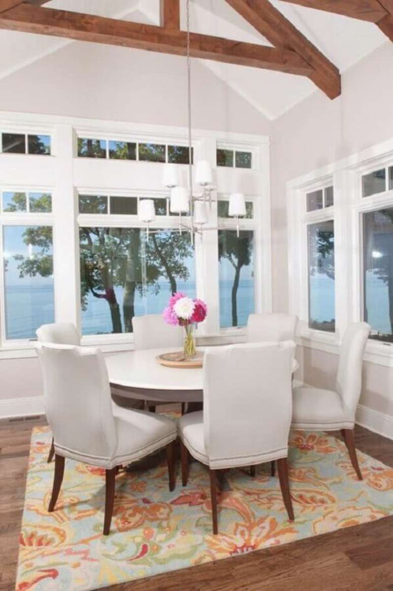60. Mesa com cadeira branca para sala de jantar com amplas janelas e mesa redonda – Foto: House of Turquoise