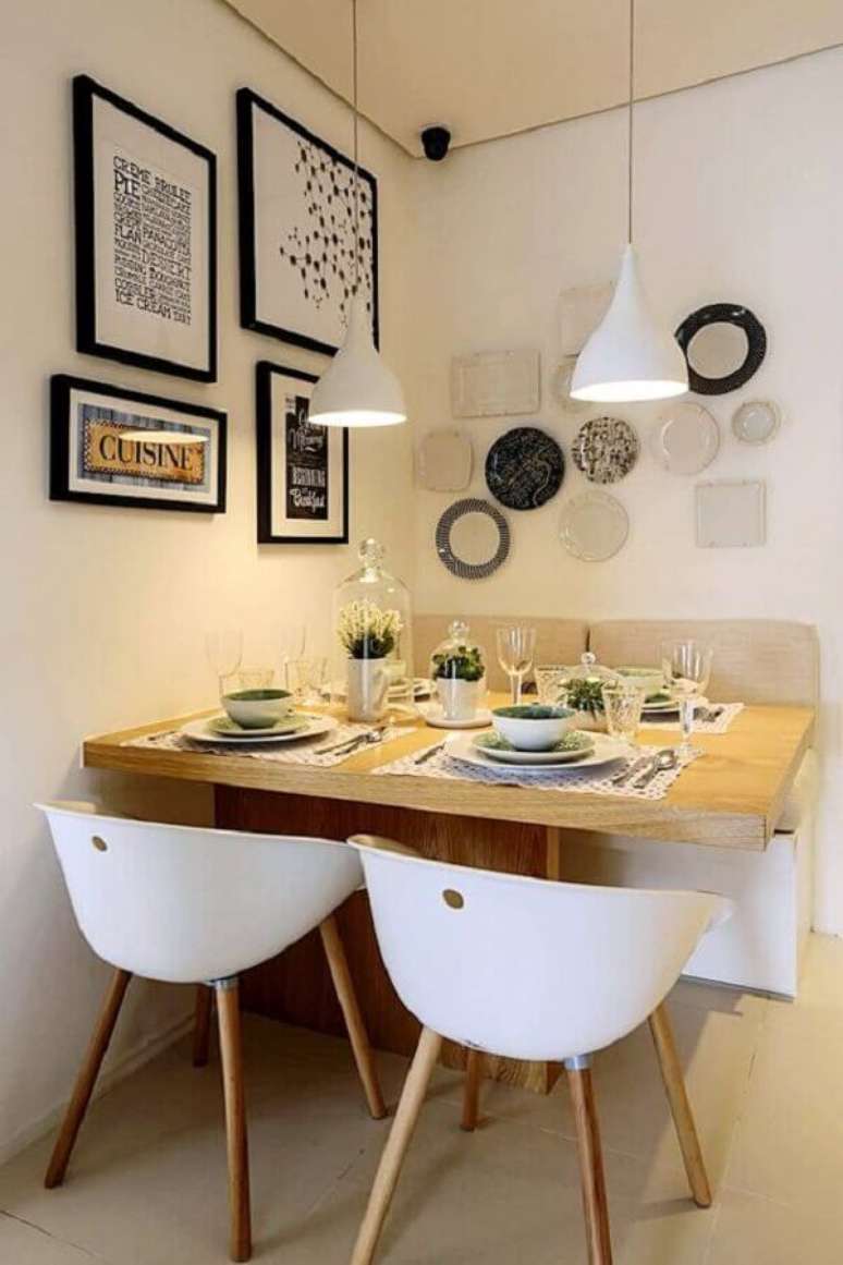 70. Sala de jantar pequena decorada com cadeira branca e vários quadros na parede – Foto: Simples Decoração