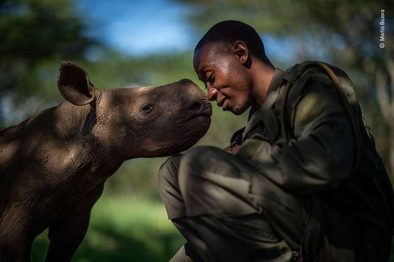 Martin Buzora fotografou o encotnro de um guarda florestal com um filhote de rinoceronte, um dos muitos que recebe cuidados do guarda