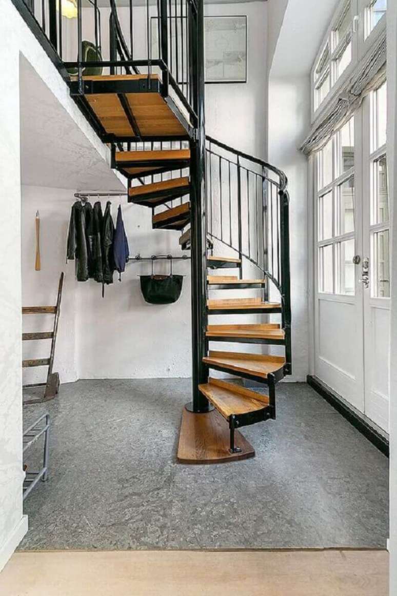 55. Casa com decoração minimalista com escada caracol de ferro com degraus de madeira
