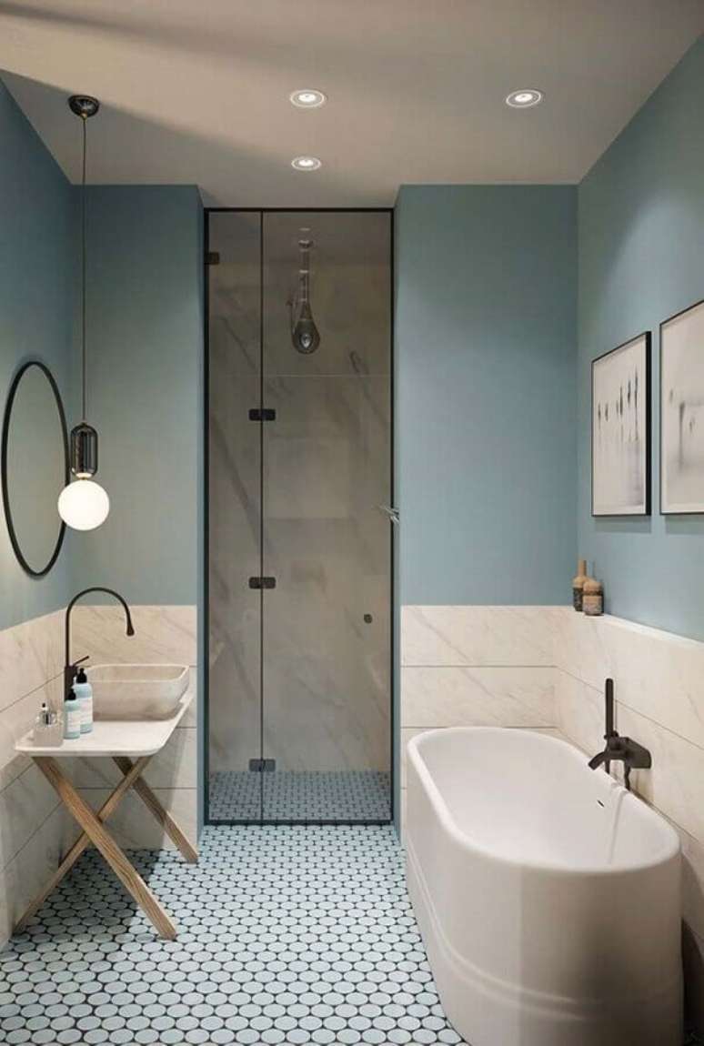 10. Tons pastéis azuis para decoração de banheiro com banheira pequena e piso com padronagem – Foto: My Social Mate