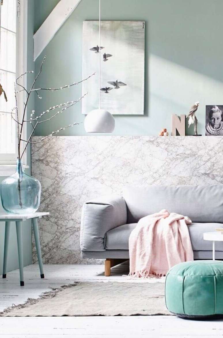 13. Paleta de cores tons pastéis para sala de estar decorada com sofá cinza e revestimento de mármore para parede – Foto: Ideas Decor