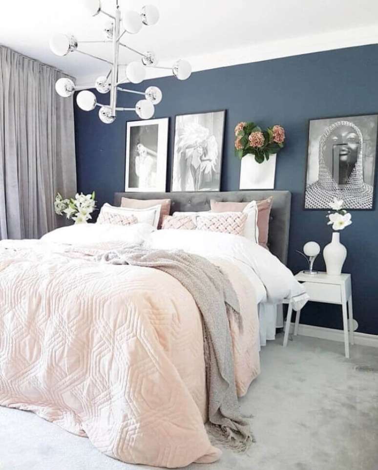 21. Quarto moderno com decoração feminina com parede azul escura e roupa de cama em cores tons pastéis – Foto: Linda Wallgren