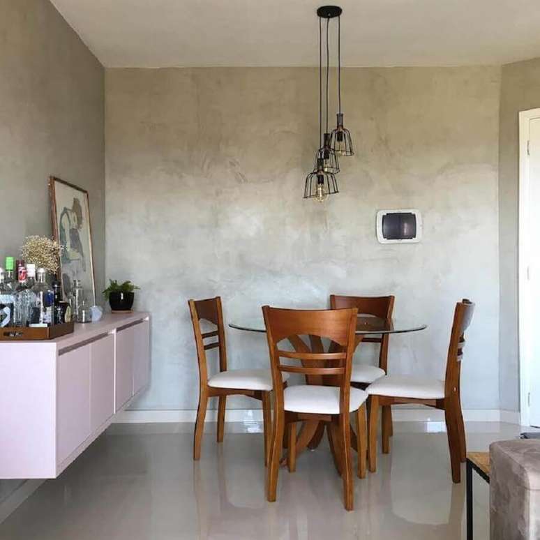 41. A parede de cimento queimado d&aacute; um toque moderno junto com o pendente aramado para a sala de jantar em tons past&eacute;is &ndash; Foto: Apartamento 501