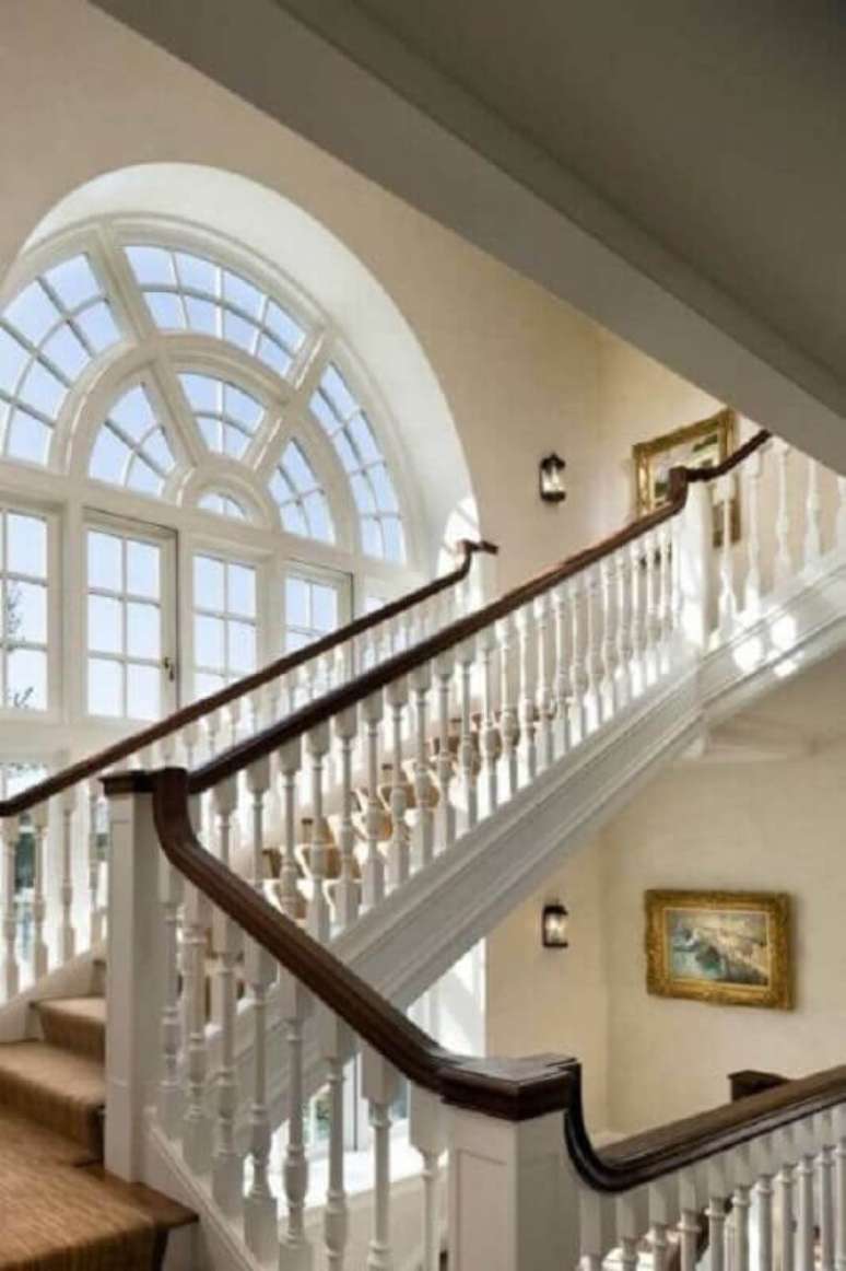 42. A escada branca com corrim&atilde;o escuro fica linda e bem destacada