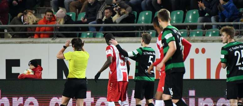 Leroy Kwadwo (c.) é consolado por jogador da equipe adversária após insultos racistas de torcedor