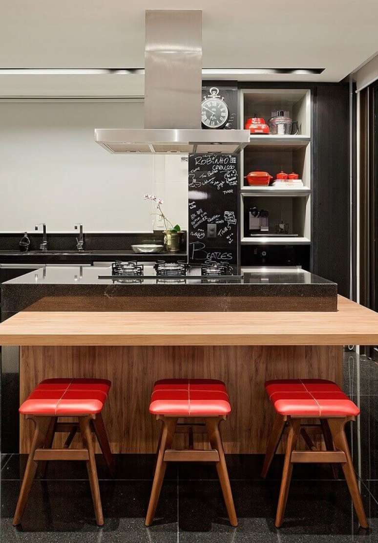 44. Ilha de cozinha com cooktop e bancada de madeira com banquetas baixas – Foto: Casa de Valentina