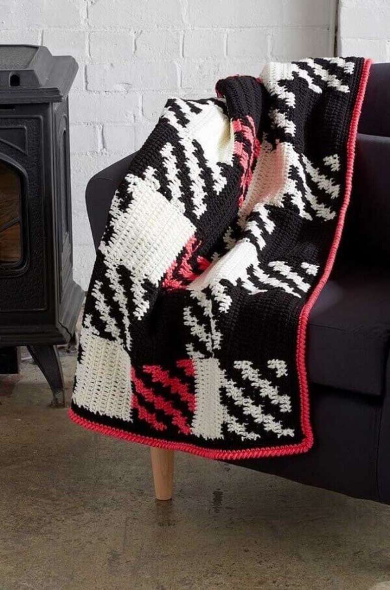 17. A manta colorida feito em crochê tunisiano trouxe vida ao sofá preto. Fonte: Pinterest