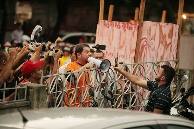 Cid Gomes (PDT) (de camiseta laranja) fala com manifestantes durante protesto de policiais na cidade de Sobral