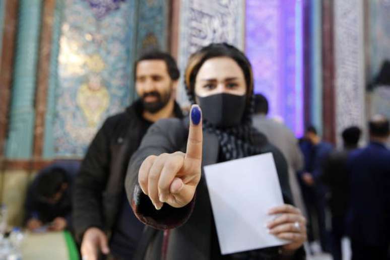 Eleitora iraniana mostra dedo com tinta após depositar seu voto