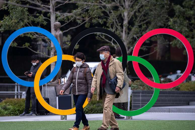 Pessoas com máscara de proteção passam pelos anéis olímpicos em Tóquio
26/02/2020
REUTERS/Athit Perawongmetha