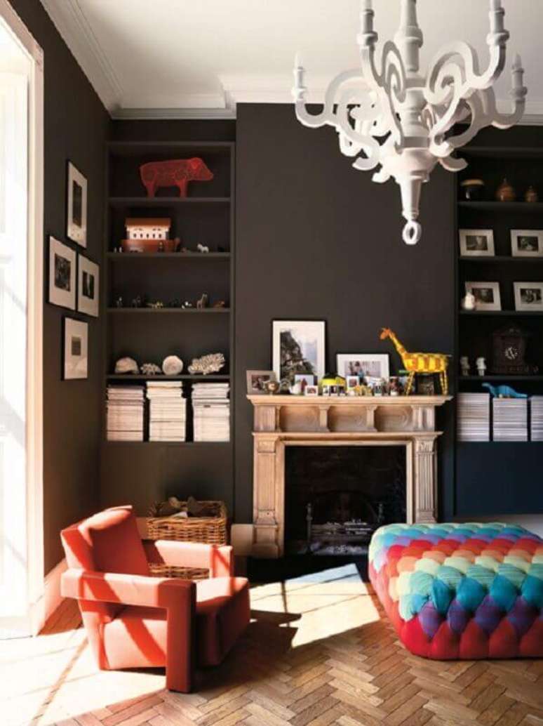 3. Decora&ccedil;&atilde;o moderna para sala com paredes pintadas e preto e mesa de centro puff capiton&ecirc; colorido &ndash; Foto: Pinterest