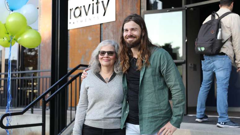 Dan Price com a mãe dele na frente da sede da Gravity