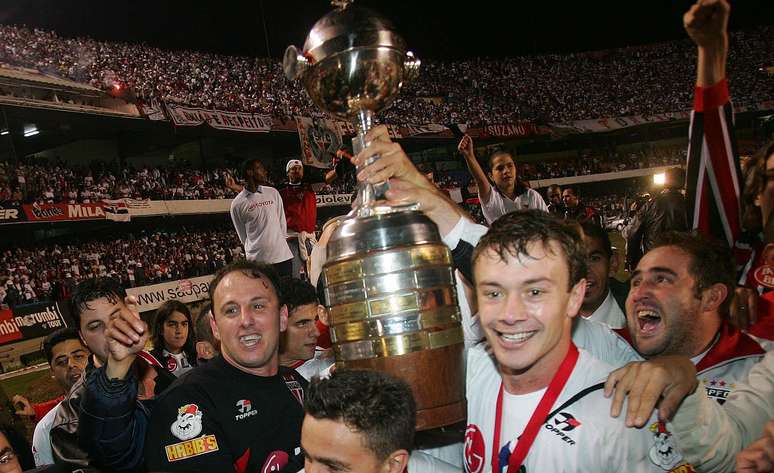 Rogério Ceni (esq.) e Lugano (2º à dir.) levantam a taça de campeão da Copa Libertadores da América em 2005 após o São Paulo vencer o Atlético Paranaense por 4 a 0 no estádio do Morumbi