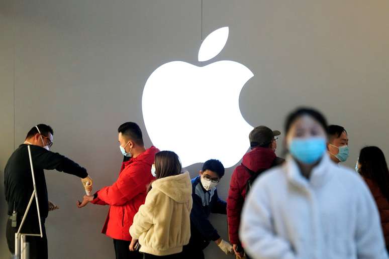Pessoas usando máscaras de proteção esperam para medir sua temperatura numa loja da Apple, em meio a surto de coronavírus. 21/2/2020. REUTERS/Aly Song