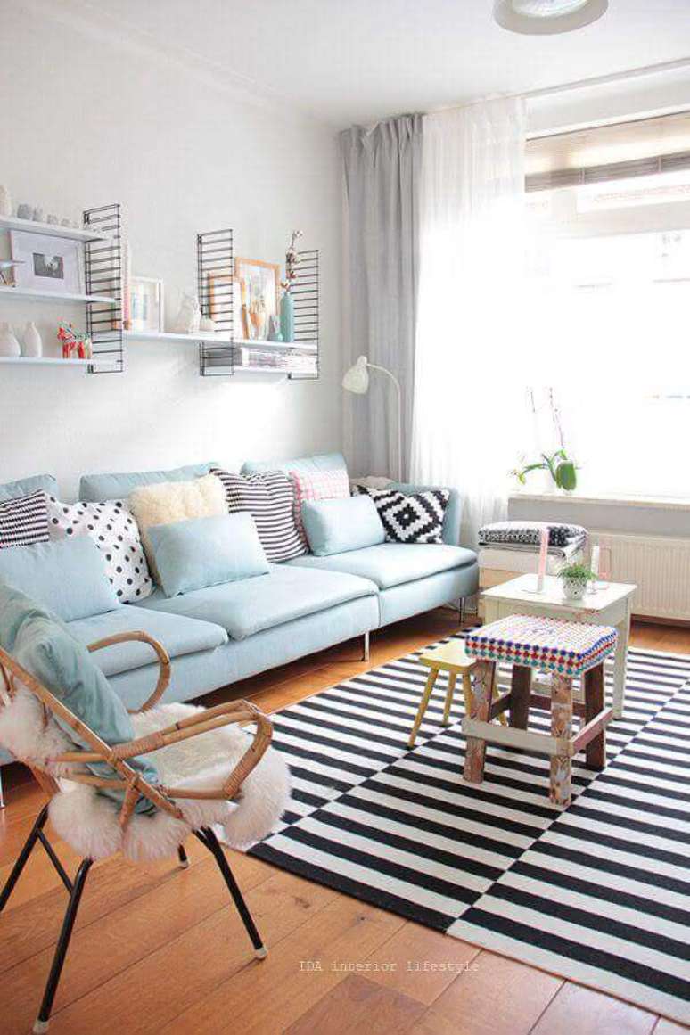 71. Decoração de sala pequena e clean com sofá azul claro e tapete listrado preto e branco – Foto: Apartment Therapy