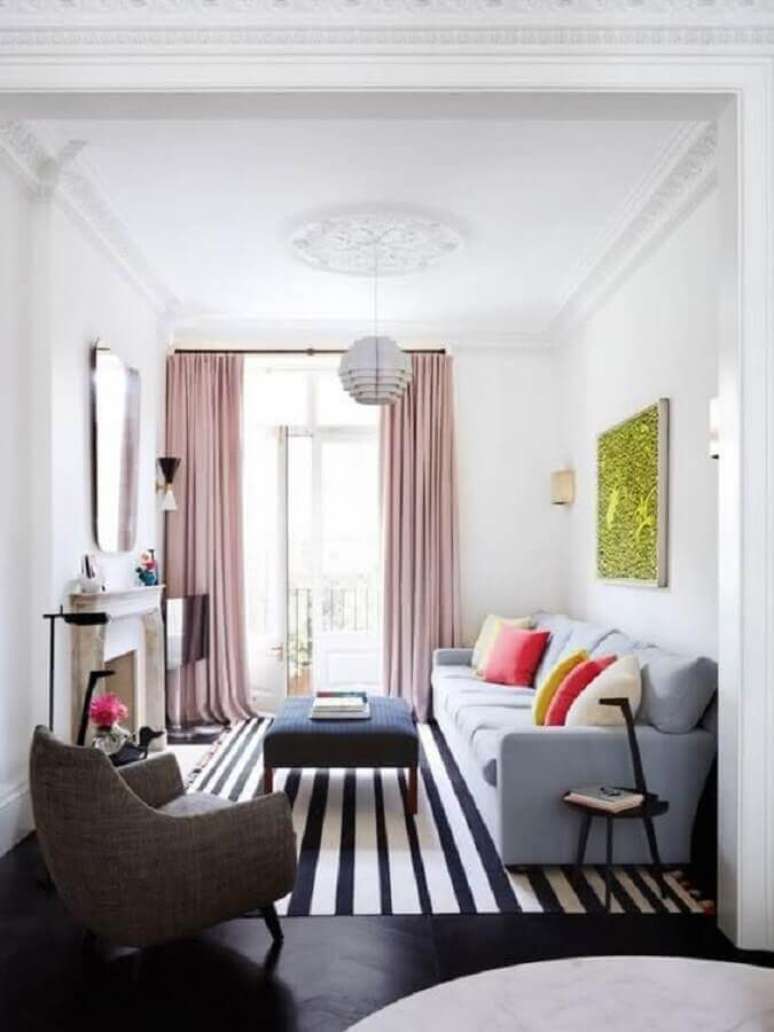 77. Delicada decoração de sala de estar com tapete listrado, sofá azul claro e cortina rosa – Foto: Ideias Decor