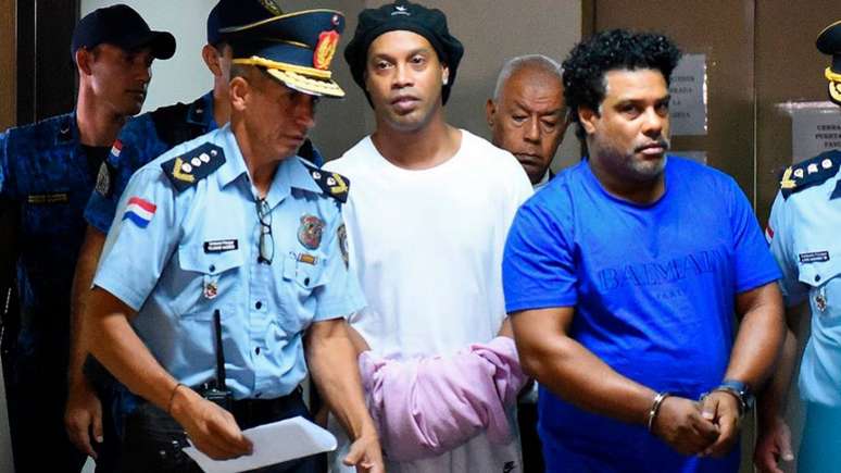 Ronaldinho e Assis chegaram algemados, antes da audiência com a Justiça  (Norberto DUARTE / AFP)