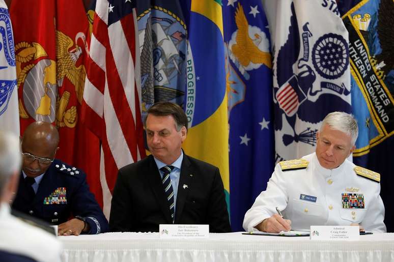 O comandante Craig S. Faller, do Comando Sul dos EUA, durante cerimônia de assinatura de acordo, ao lado de Bolsonaro, em Miami