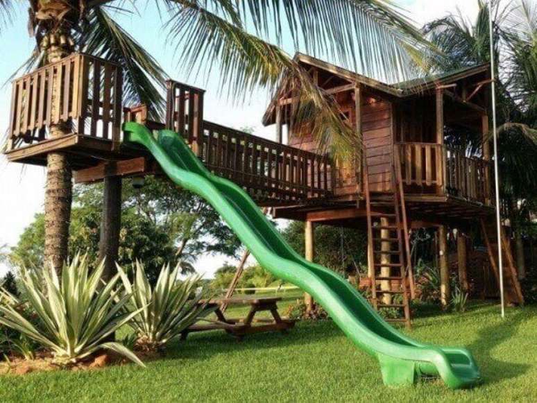 37. O escorregador verde trouxe cor para o projeto da casa na &aacute;rvore. Fonte: Pinterest