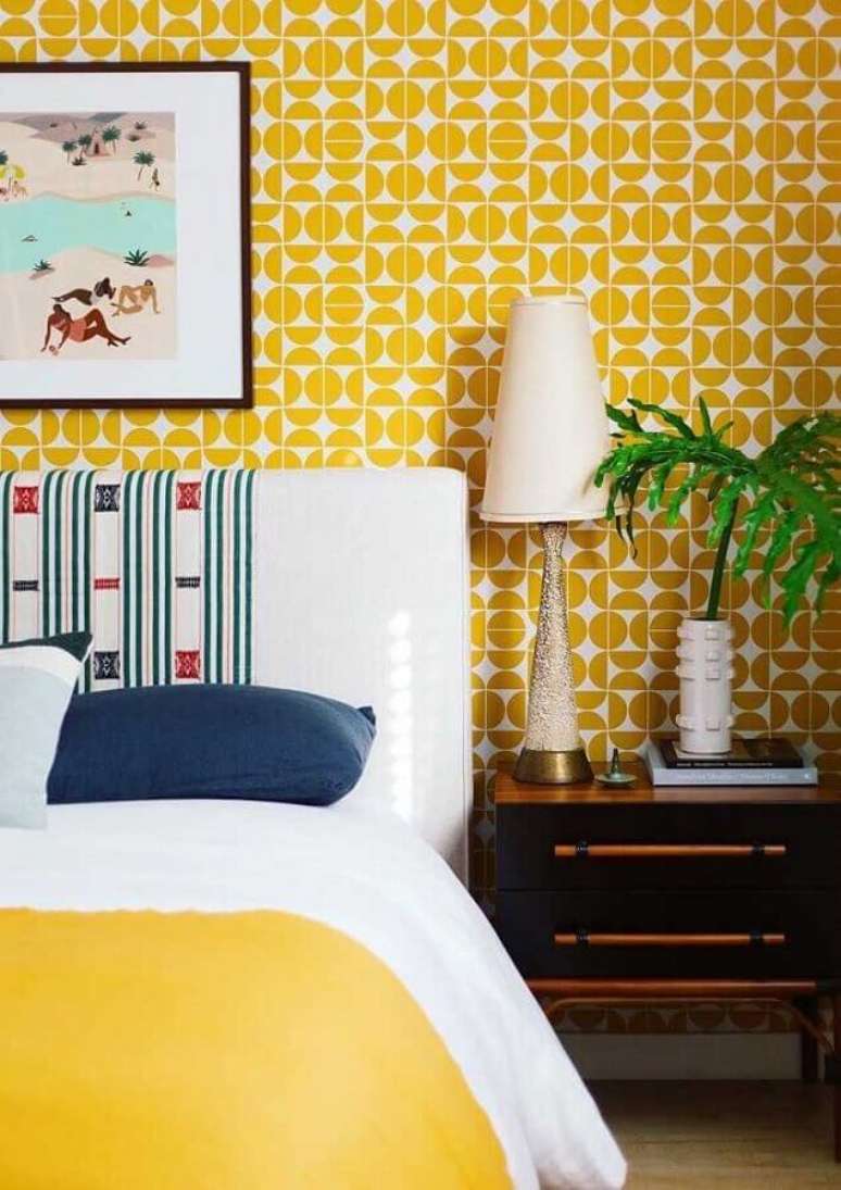 1. Papel de parede para decoração de quarto amarelo com criado mudo de madeira – Foto: Arquitetando Estilos