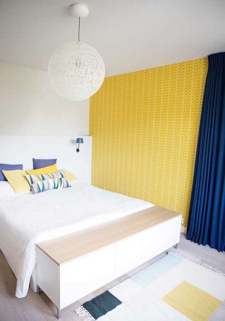 42. Decoração simples para quarto amarelo e branco com papel de parede e cortinha azul – Foto: Assetproject