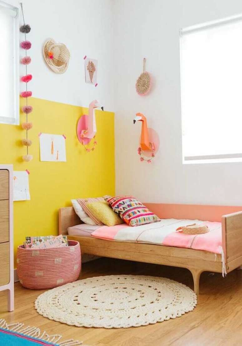 52. Quarto de menina amarelo decorado com tapete redondo de crochê e cama de madeira – Foto: Pinterest