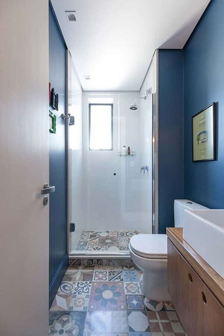 78. Decoração para banheiro pequeno com paredes pintadas de azul e piso hidráulico – Foto: Pinterest