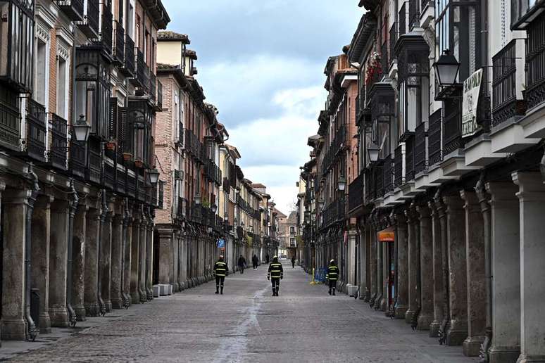 Na cidade de Alcala de Henares, perto de Madri, policiais fazem a ronda em uma rua vazia. Na Espanha, pessoas estão proibidas de sair de casa, exceto para comprar suprimentos essenciais e medicamentos, ou ir ao trabalho