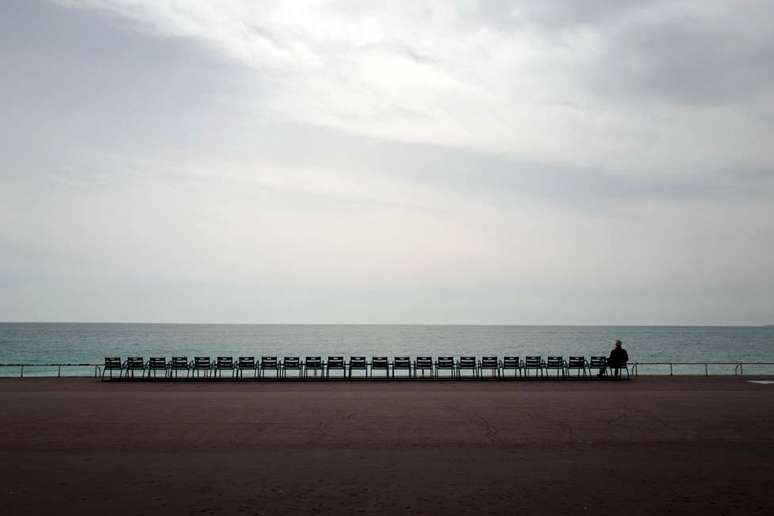 Um homem observa o Mediterrâneo na avenida Promenade des Anglais, em Nice, na França. As regras de isolamento social no país começaram a valer nesta última semana.