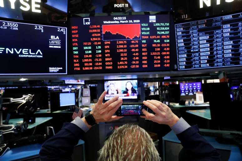 Operador tira uma foto de telas exibindo informações de negociação no pregão da Bolsa de Nova York (NYSE) em Nova York, EUA. 18/03/2020. REUTERS/Lucas Jackson