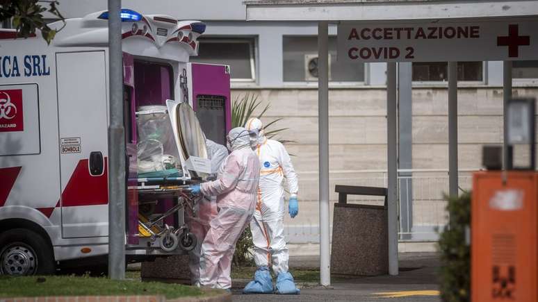 Equipe médica coleta um paciente de uma ambulância na Itália