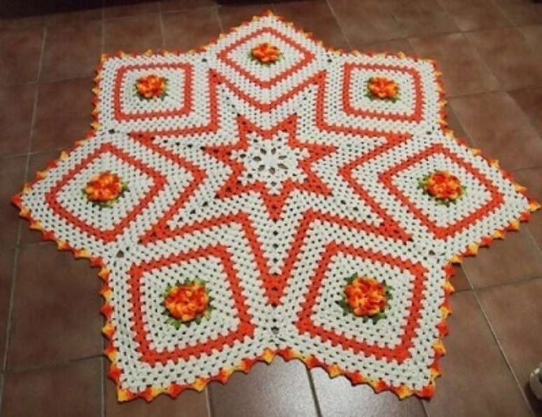 59. Tapete de crochê para cozinha com formato de estrela laranja e branco