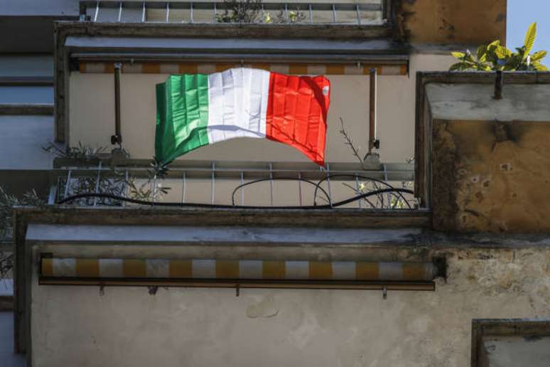 Bandeira da Itália em sacada de Roma, em solidariedade às vítimas do novo coronavírus