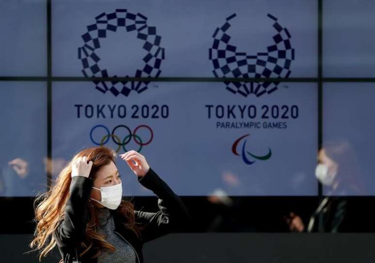 Mulher com máscara de proteção contra coronavírus caminha em frente a painel com a logo dos Jogo de Tóquio
19/03/2020
REUTERS/Issei Kato