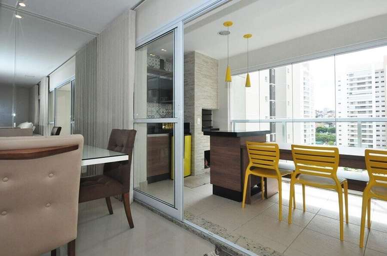 36. Área gourmet pequena de apartamento decorada com cadeiras e pendentes amarelos – Foto: Condecorar Arquitetura e Interiores