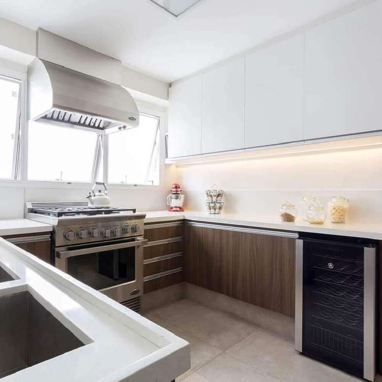 4. Decoração simples para cozinha com armário planejado branco e bancada de madeira – Foto: BMG Arquitetura