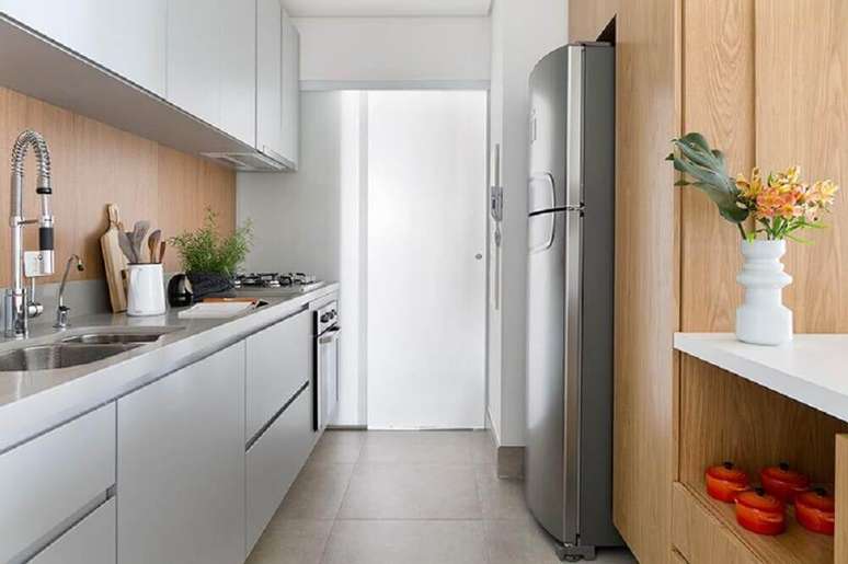 79. Os toques de madeira deixam o ambiente com armário de cozinha planejado mais aconchegante – Foto: Doob Arquitetura